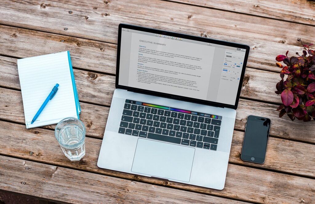 Laptop on wooden table - Resume Writing Tips
