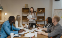 Group of 5 people in an office meeting