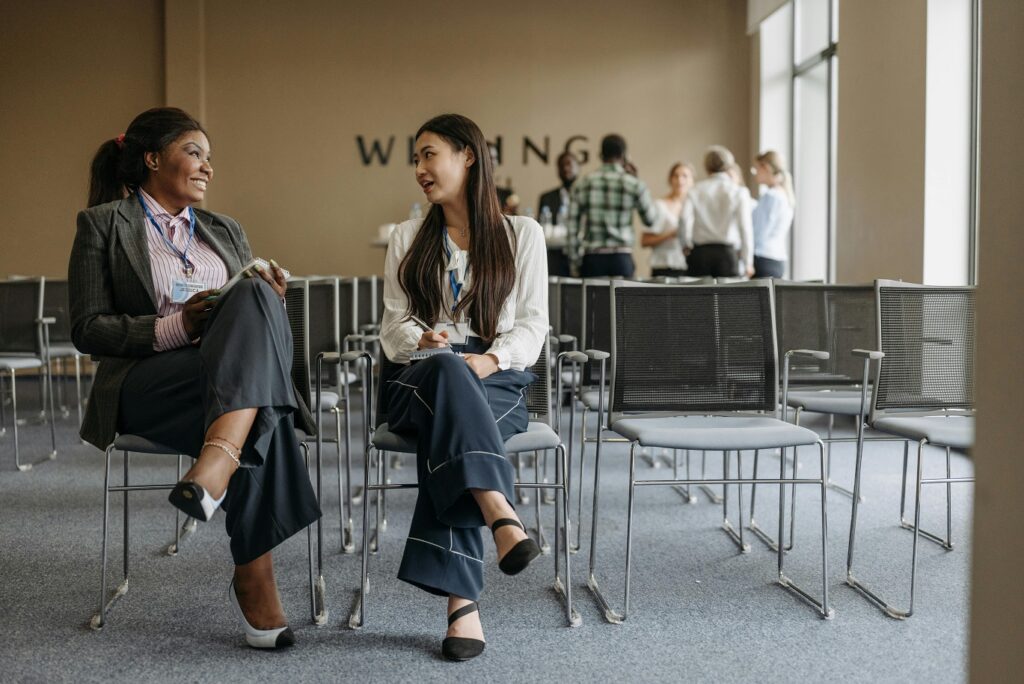 two people sitting on chairs talking to each other